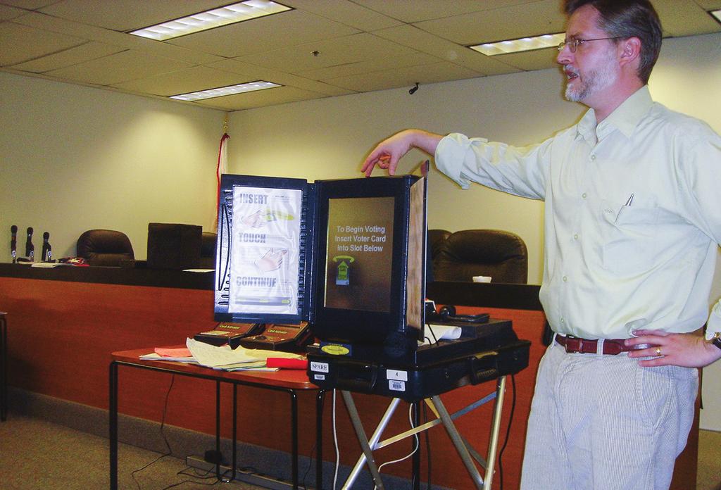 Një zyrtar zgjedhor trajnon administratën zgjedhore për përdorimin e një pajisjeje për votim elektronik me regjistrim të drejtpërdrejtë në Shtetet e Bashkuara, 2006.