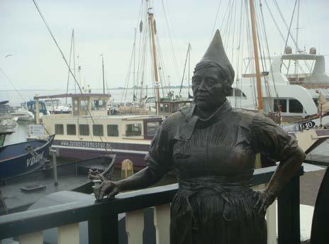 Statue of a Dutch Lady in the harbour A boat for the