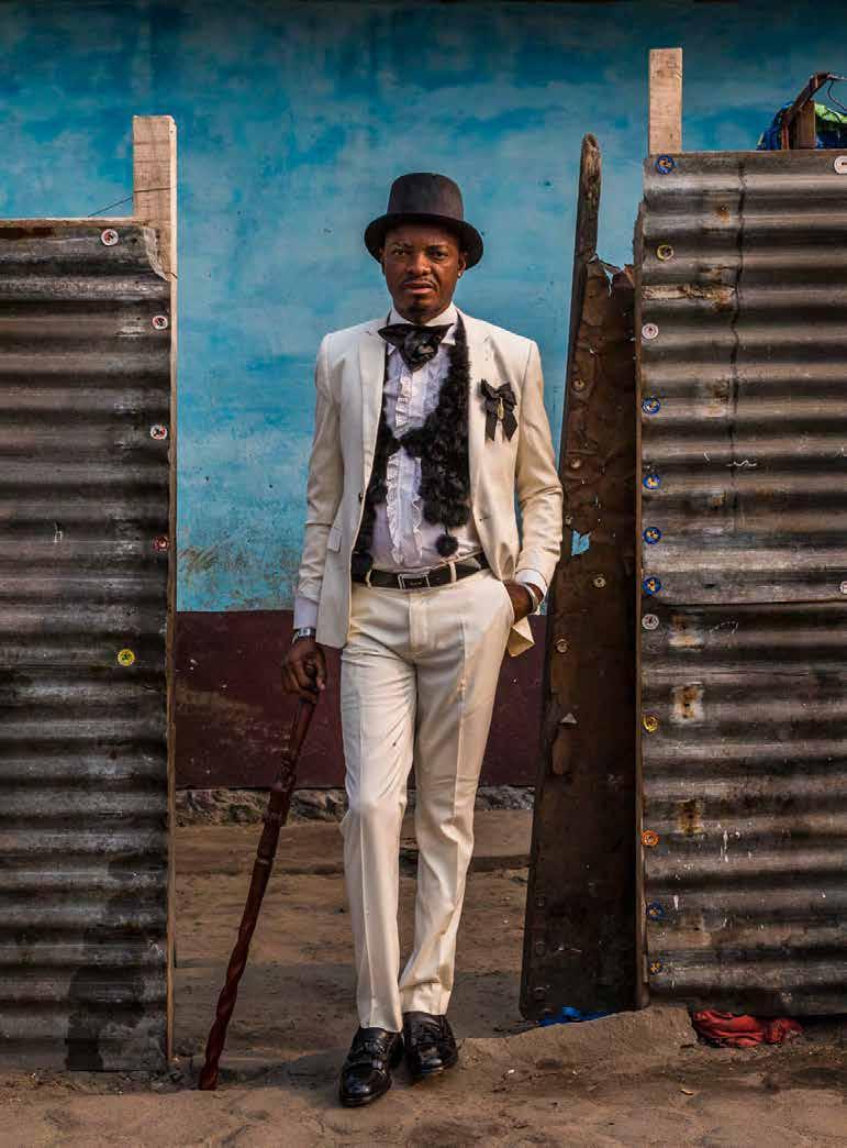58 / HERITAGE / Fashion HERITAGE / 59 Celestin (67) cuts a stylish figure outside a local shop. He has been a Sapeur since he was 12.