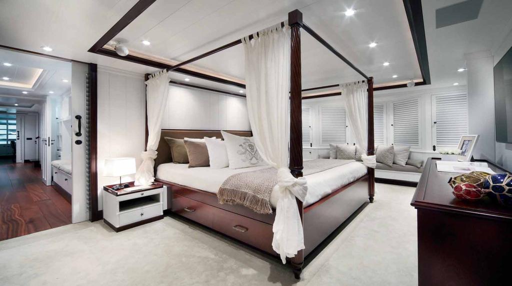 On this page: the master stateroom dominated by the large canopied bed in dark mahogany with the bed headcovered in mochacoloured calf leather.