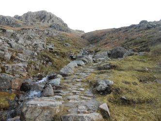 Up on the right high above is a large rock outcrop (Tarn Crag) and the route will