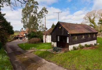 The driveway passes The Granary and arrives at a parking and turning area in front of the house with access to the nearby garage/workshop with first floor storage area and to one side a large wood