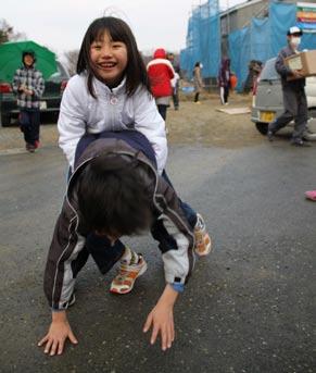 AFLO Children laugh and play outside an evacuation center in Ishinomaki, Miyagi Prefecture, two weeks after the March 11 earthquake. Front Cover: Se