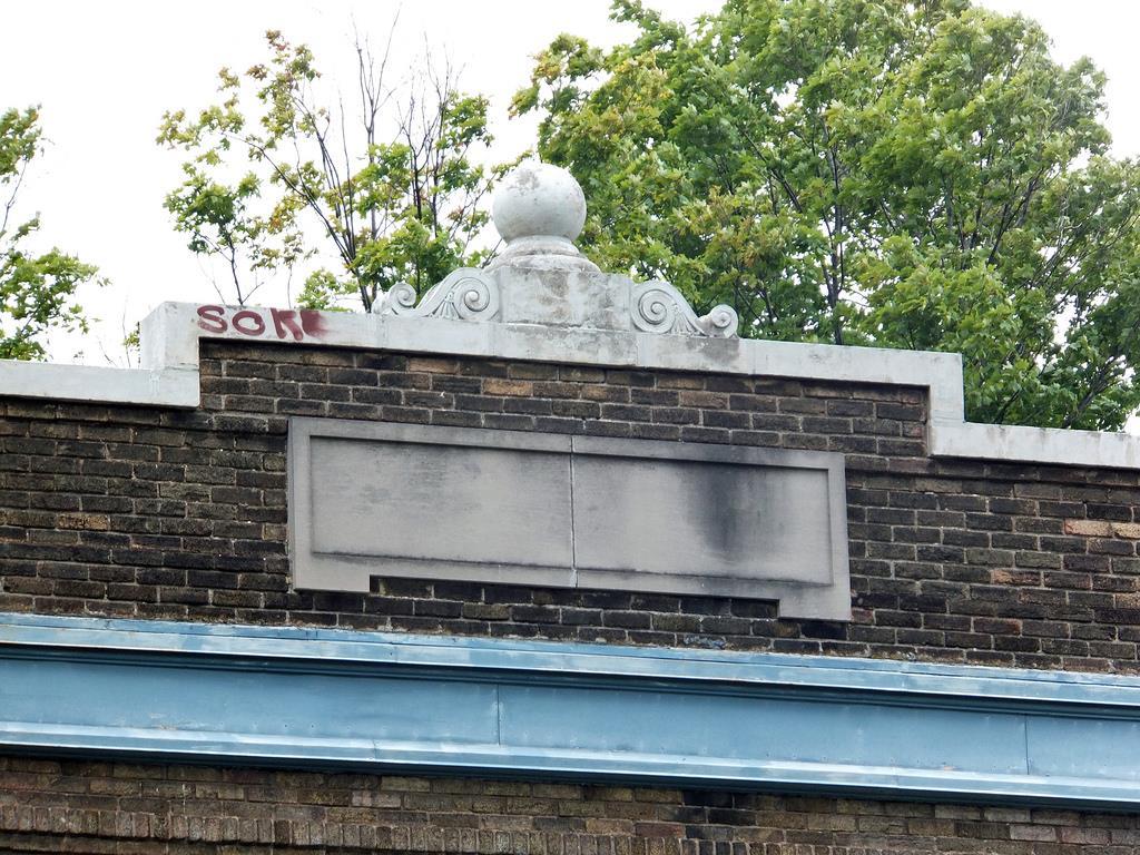 Decorative finial feature and inset stone atop the building s modest