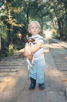 C B Before this bridge in Pine Forest one of the longest in Hopkins County was torn down in 1990, JAN FLOYD took this photo of her grandson, BRIAN FLOYD,3, with his best pal TINY.