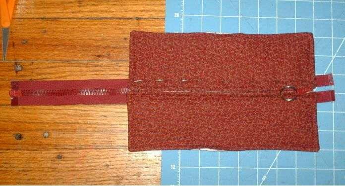 After you sew on the zipper do the same trim and sew over the teeth and fold under of the end of the zipper.