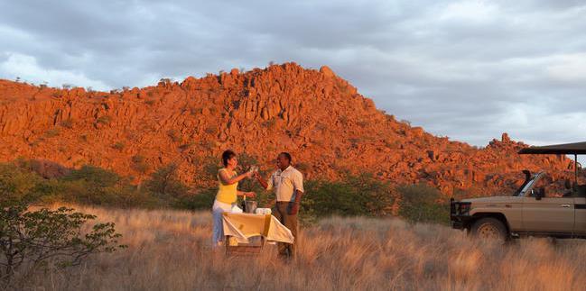 Dwarfed by massive ochre boulders, the camp is absorbed into the landscape, making it