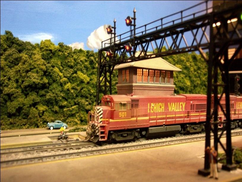 Operations include 8 track staging at east end (Jersey City) and 11 track staging at west end (Wilkes-Barre). The model railroad is double decked with 4 3/4 turn helix in one corner.
