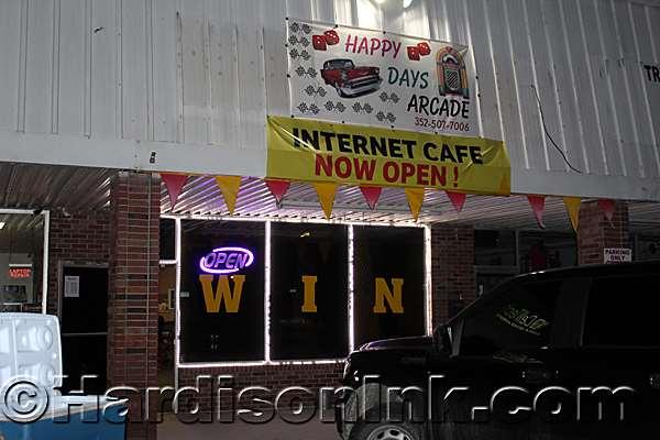 This Internet Cafe named Happy Days Arcade has its 'Open' sign lit on Saturday night, but the police presence