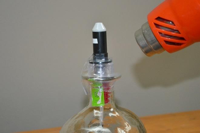 Turn the bottle as you apply heat to shrink the seal using a heat gun.
