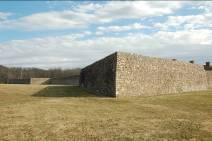 The main gate is located in the center of the south curtain wall. Two of the three barracks have been restored.