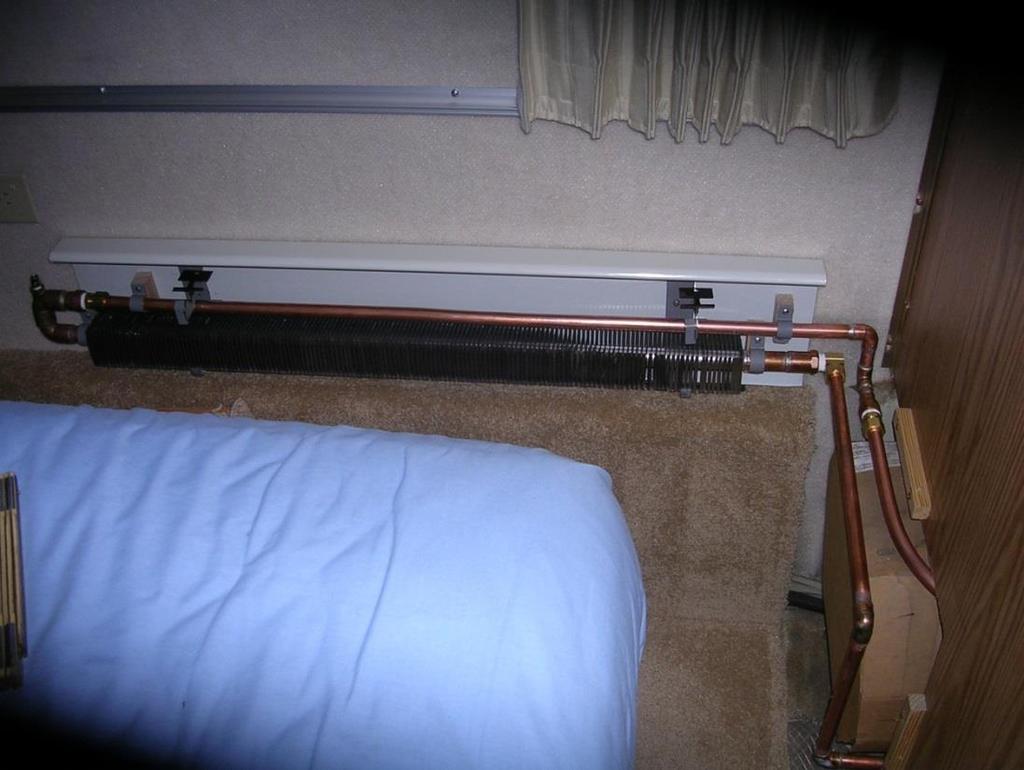 To the right is another heat exchanger in the couch area. The third heat exchanger is in the bedroom, note the lines through the wall back to the hot water tank.