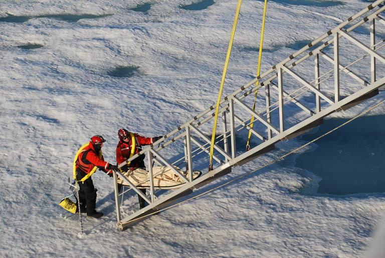 walking around on ice or going up and down the brow), high power cordless drills, and ice anchors. HEALY crewmembers load science equipment onto the ice for a science station F.