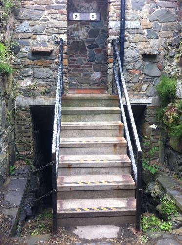 short narrow tunnel (watch your head) and ascending a second flight of 7 steps with a handrail. (See map for directions to toilets).