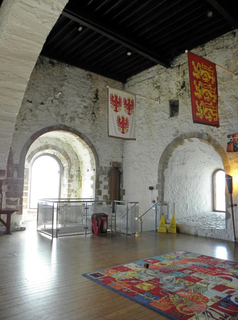 Fig. 14. Carrickfergus Castle. The great upper chamber on the 3rd floor looking toward the south-west corner with door leading to the second spiral stair to roof level.