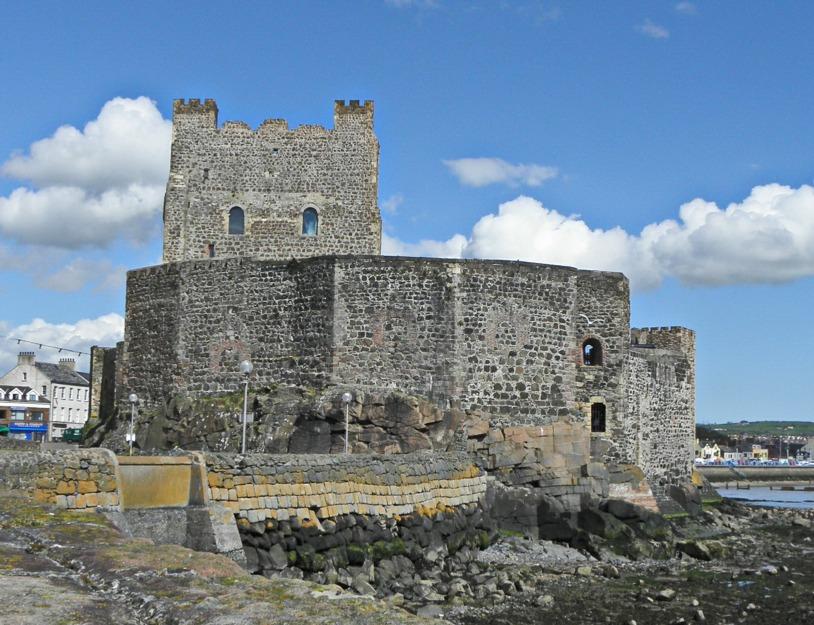 Fig. 6. Carrickfergus Castle from the south, seaward side. Faceted C12 Inner bailey wall and keep, or great tower of c. 1180-1200. Harbour to the left. Carrickfergus Castle, Co.
