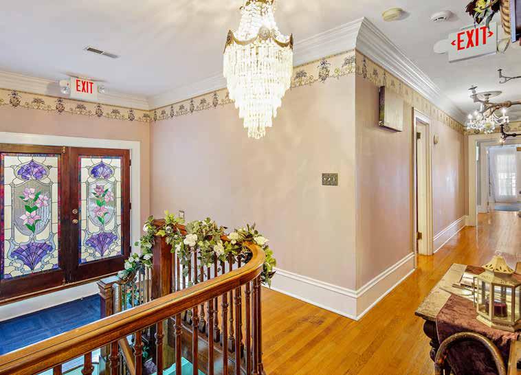 The foyer area leading to the upper level is arranged with period pieces and provides a