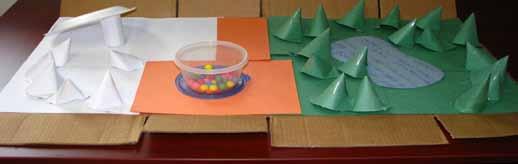 Step 3 For the fall section, place the small box or container in the middle of the board. Fill it with gumballs.