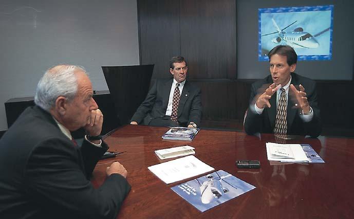 Photos by Jack Sykes (L-R) Lacy and Brollier listen as Cessna Citation Mgr of Product Marketing Michael Pierce describes the large-cabin design philosophy behind the Excel.