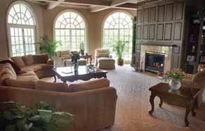 Living Room: Beyond the elegant two-story foyer lies the grand living room, rich in architectural detail with the spectacular backdrop of a