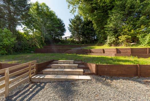 The rear garden is stepped and mainly down to lawn with mature trees providing privacy and shelter.