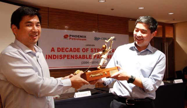 Phoenix Petroleum President and CEO Dennis Uy gives a brass sculpture created by 2006 TOYM Awardee