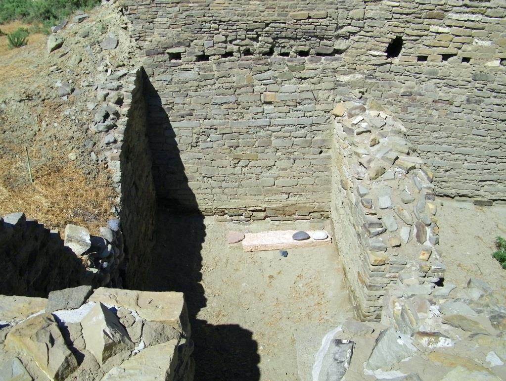 The flat stone at the bottom right of this Salmon pueblo room has two rocks on it, one black and one white.