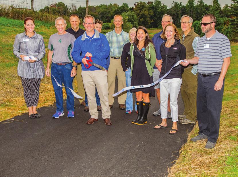 Volunteers, local government officials, and trail supporters at the ribbon cutting celebrating the completion of Phase II of the Buffalo Ridge Trail from West Middle School to the new YMCA.