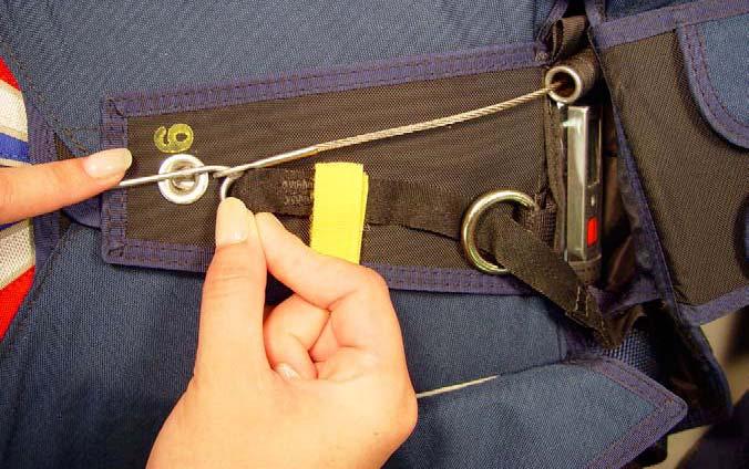 Insert the pin-end of the RSL through the guide ring on the #6 top reserve flap. Mate the patch of yellow pile hook and loop fastener on the top reserve flap.