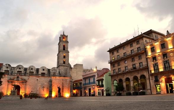 Plaza de San Francisco de Asis, a paved space with fluttering pigeons, framed by historic buildings such as the Convent and the Church of St.