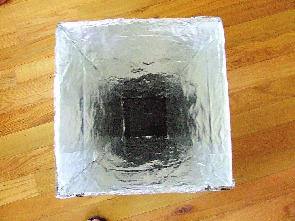 To create the base of the solar cooker, cut a piece of cardboard that will fit the opening