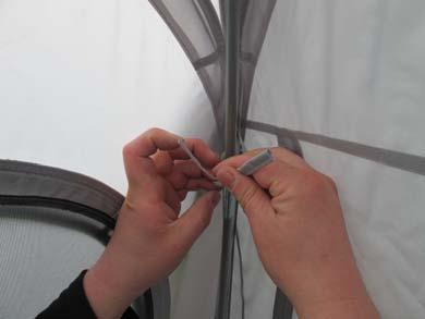 Take the groundsheet inside the awning and locate one of the plastic clips that are