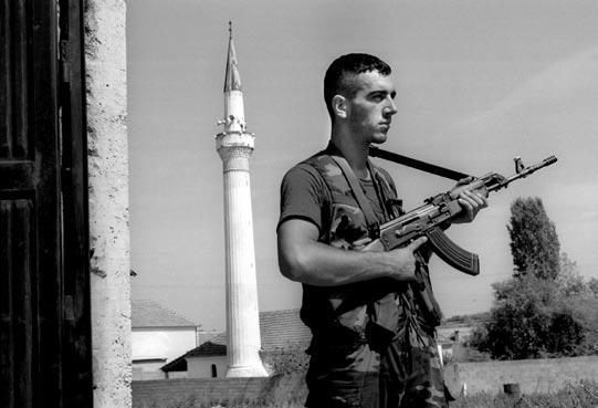 Local Governance Reform in Kosovo: Milestones for the Promotion of Tolerance Algirdas Petkevicius An Albanian fighter during the Kosovo conflict stands guard in the village of Dobrosin.