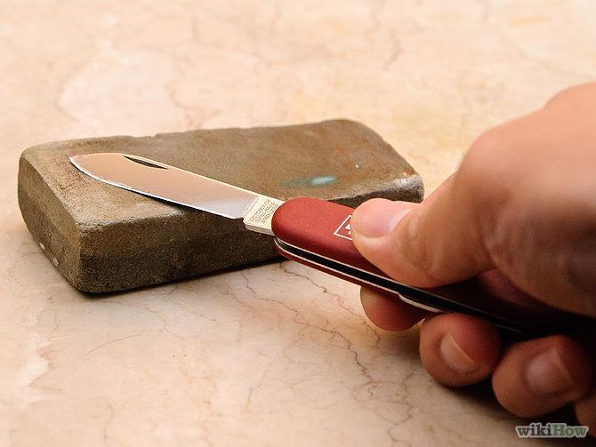 Maintain the knife's position with the blade facing away from you at the determined bevel angle against the whetstone when sharpening.