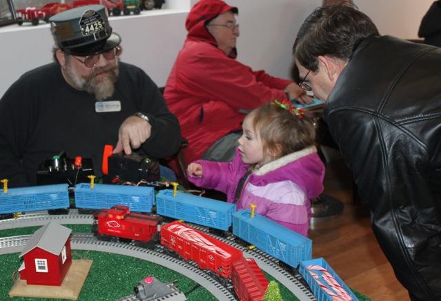 Mitch Marmel shows Miss Fenix how to operate the O gauge layout.