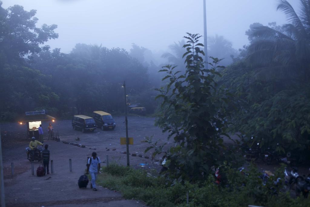 The end of the journey: a monsoon- textured evening and travelers leaving the station at Ratnagiri.