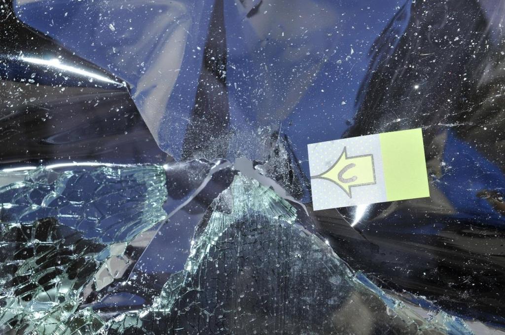 (Detail of bullet strike C) The driver s side window was heavily damaged in the crash.