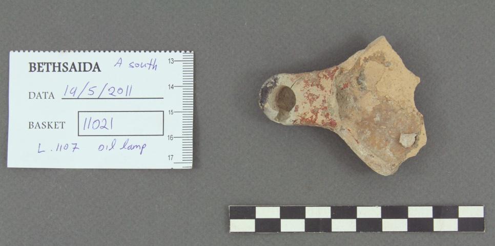 Figure 7, Roman oil lamp near the Roman city wall. 4. The floor of the passageway was coarsely paved with small and medium stones with remains of white plaster on top of it.