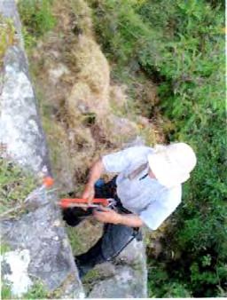 1. A single wooden post had been driven into the ground as a rappel anchor. Multiple metal anchors properly tied together provide increased security. 2. No climbing harness or helmet was being used.