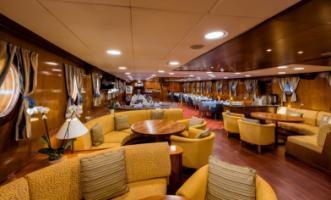 MAIN DECK LOUNGE & DINING ROOM Renovated in 2016, the main deck lounge area with an American bar leads into a warm and elegant dining room finished with wood and carpet flooring, and beautiful