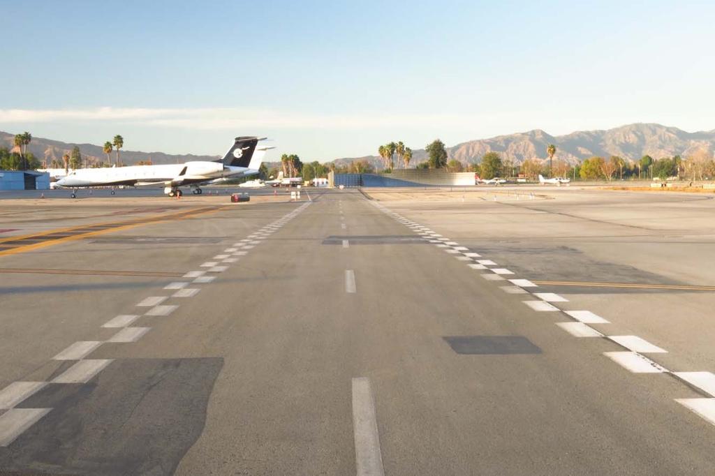 Airport Service Road Markings At Van Nuys Airport the Vehicle Service Road is delineated with white, zipper style edge stripes in certain areas.