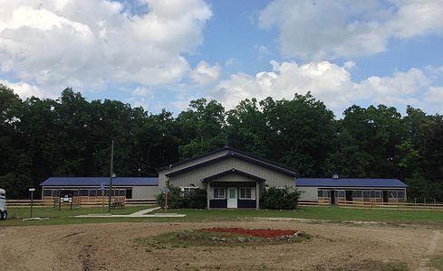 A 24-stall horse barn with a 5 room living quarters attached.