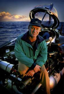 Dr. Robert Ballard The Titanic lies in 13,000 feet of water on a gently sloping alpine-like countryside overlooking a small canyon below. Its bow faces north and the ship sits upright on the bottom.