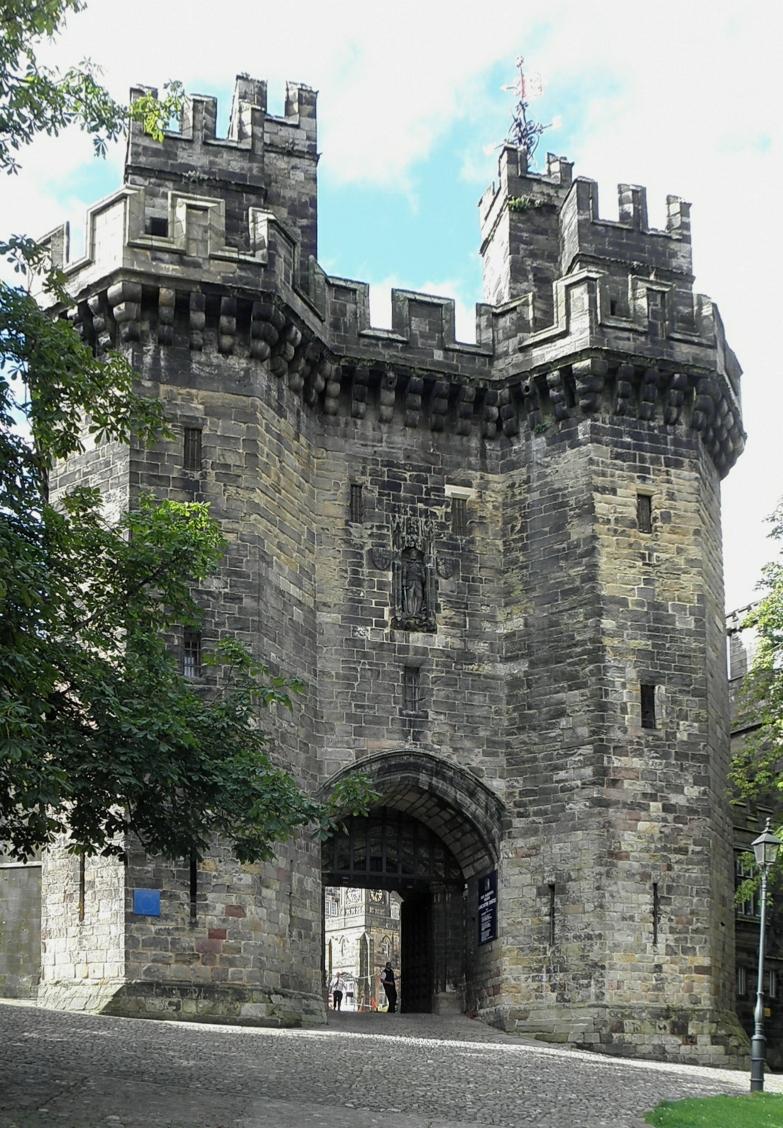 Lancaster Castle. The Henry IV gatehouse from the south-east. The C15 gatehouse subsumes a C12/13 stone gateway, observable inside the gate passage beyond the portcullis.