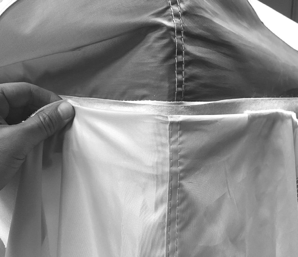 Hold the wall with the hook and loop tape facing you and fold it over, attaching it to the hook and loop strip of the valance, aligning the corner seam of
