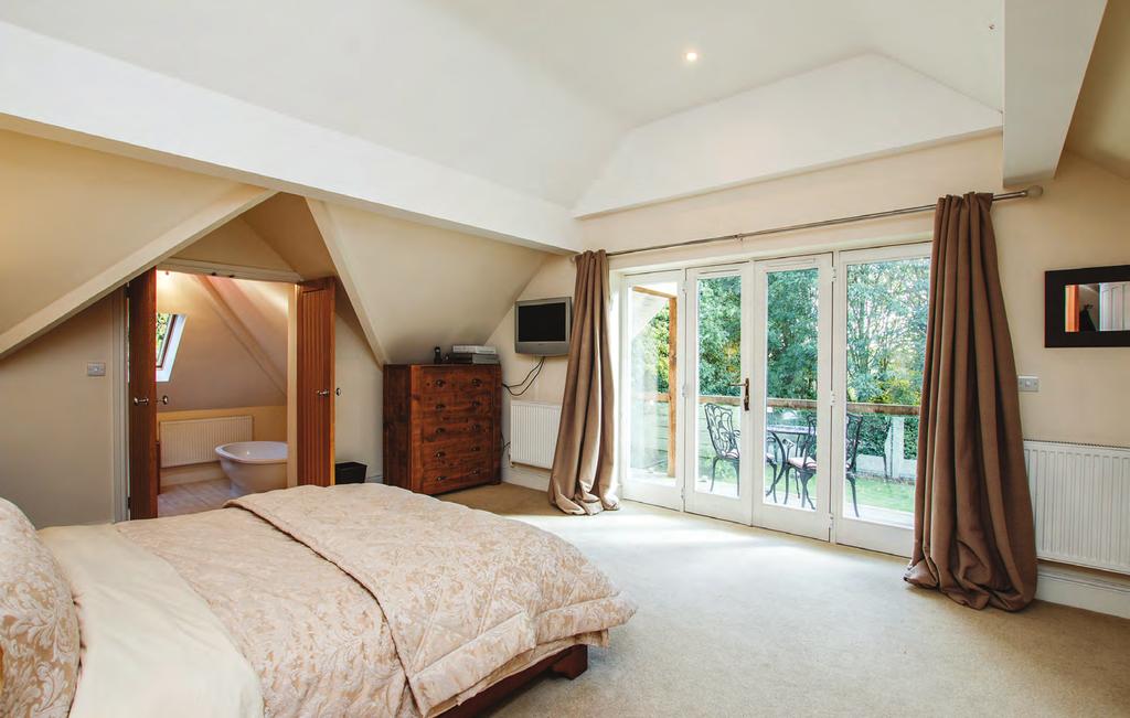 The impressive master bedroom benefits from the luxury of a large balcony overlooking the garden, and has double doors leading