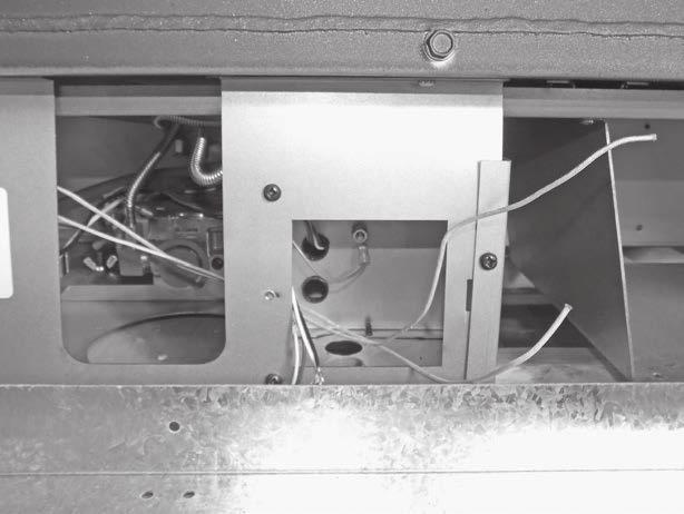 Figure 7: Bringing wires through front plate. 6. Remove the electrical connection compartment cover and feed all four lights wires through the opening.