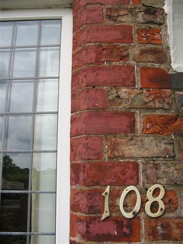 Next to the front door is an original window opening and there is a fine white line running around the edge of the bricks.