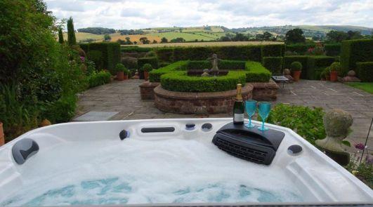 Shropshire SLEEPS 14-19 Tennis court Perfectly situated Hot Tub beyond the gated private garden, boasting stunning views across the rolling Shropshire hills.