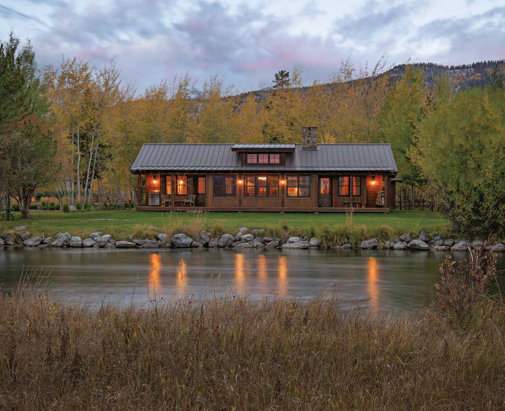 With lights aglow in the early evening, the Alpha cabin is an enticing beacon from across the meadow on the